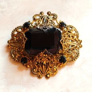 Ornate Gold and Black Brooch with Intricate Metalwork